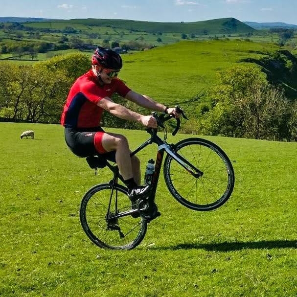 Ben doing a wheelie on a bicycle in a field